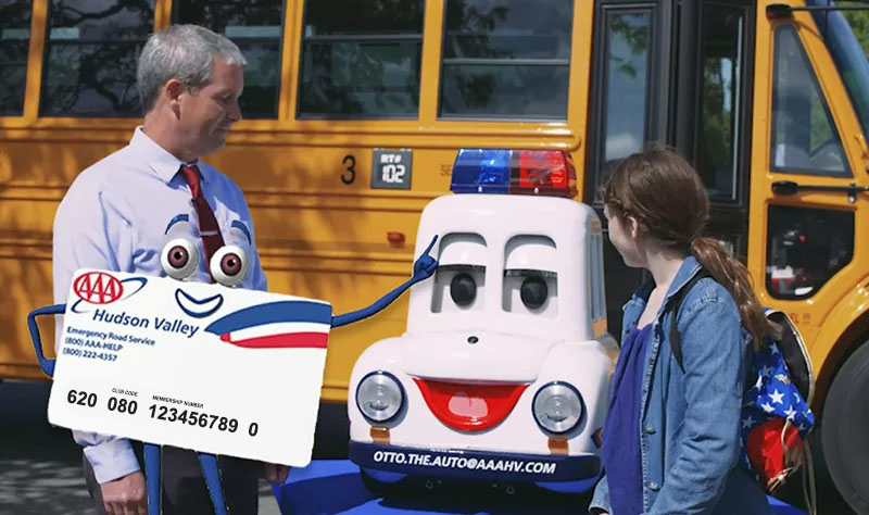 AAA card character standing in front of man and child next to AAA mascot and bus