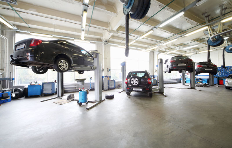 four cars on lifts at repair shop
