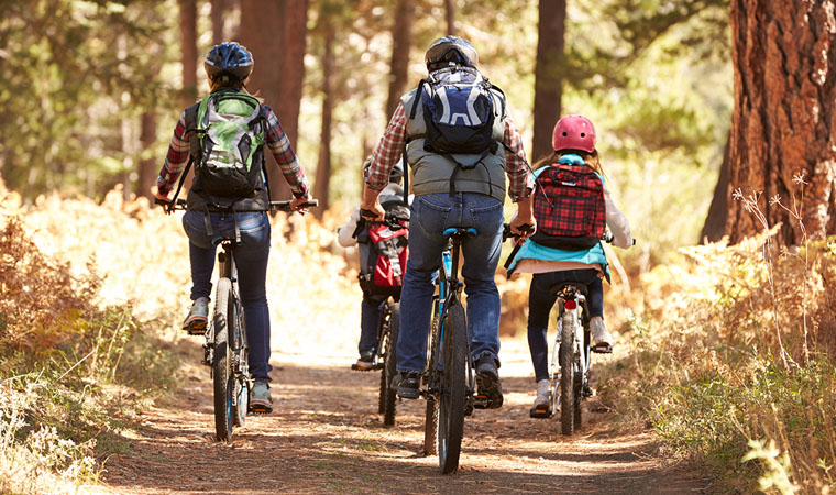 family riding bikes on a trail